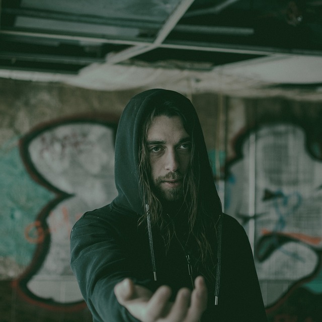 man wearing a hoodie with outstretched hand